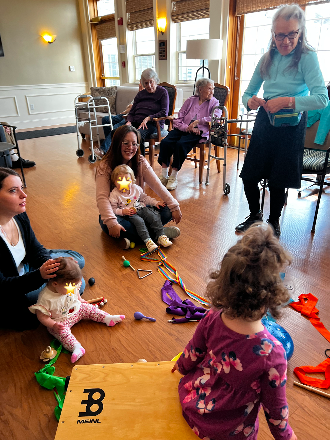 Babies, parents, and seniors together in a retirement home Bach & Boogie session