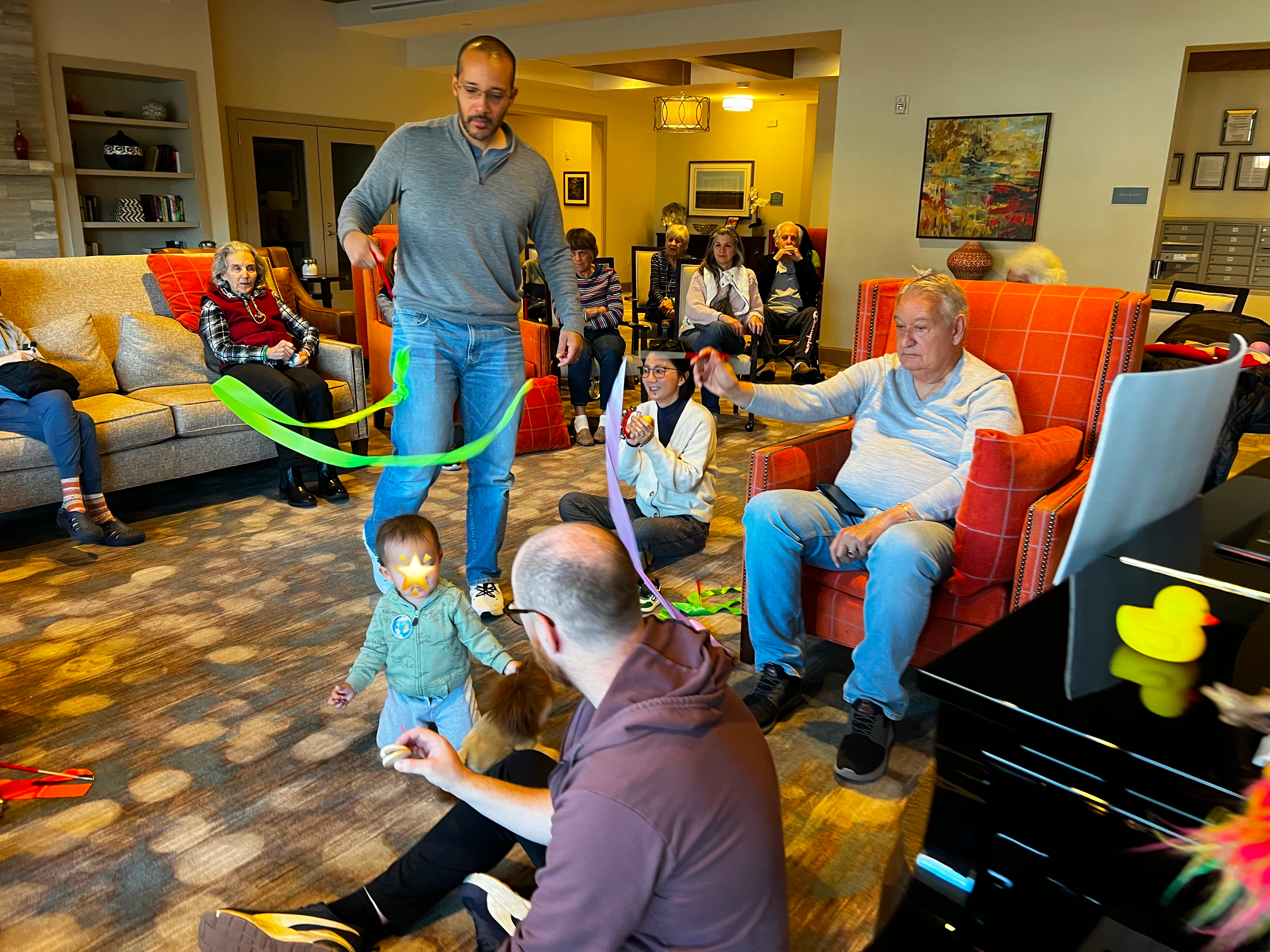 Alex facilitating a Bach & Boogie session with seniors, parents, and toddlers moving together with ribbons